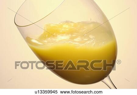 Stock Photography - Glass of orange juice, close up, colored background. Fotosearch