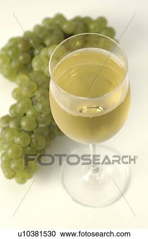 Stock Image - Glass of White Wine and Green Grapes. Fotosearch