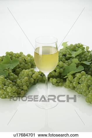 Stock Image - Glass of White Wine and Green Grapes. Fotosearch