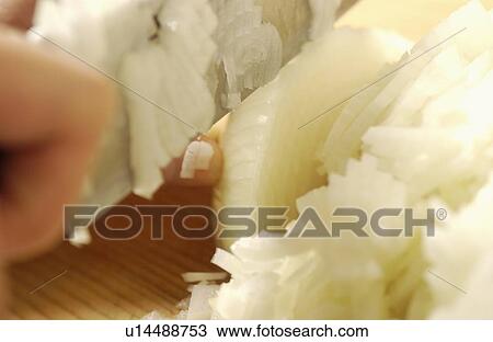 Stock Image - Hand cutting onion. Fotosearch