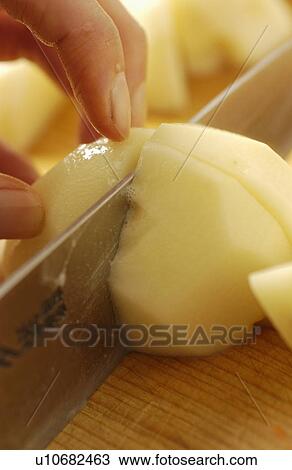 Stock Image - Hand cutting potato. Fotosearch