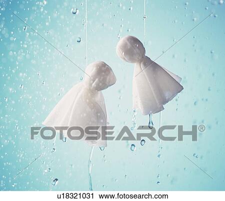 Stock Image - Hanged dolls made of white cloth, blue background. Fotosearch