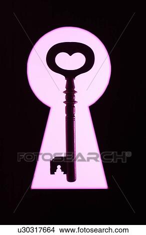 Picture - Key in frame of keyhole, black background. Fotosearch