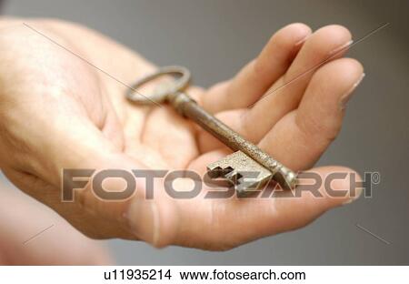 Man holding a rusted key, close up, black background View Large Photo Image Picture - Man holding a rusted key, close up, black background. Fotosearch
