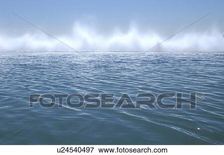 Stock Photo - Ocean surf against blue sky. Fotosearch