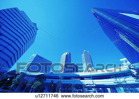 Stock Photograph - Office buildings under the blue sky in Umeda, toned image, Osaka city, Osaka prefecture, Japan. Fotosearch