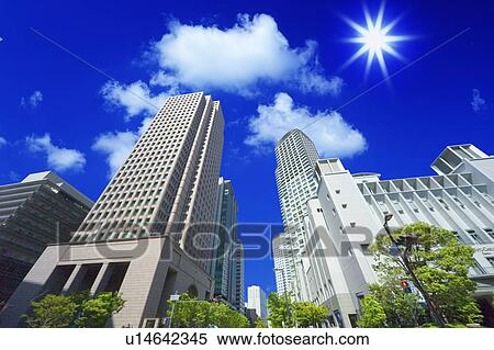 Stock Photography - Office buildings under the blue sky in Umeda, lens flare, Osaka city, Osaka prefecture, Japan. Fotosearch