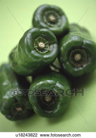 Stock Image - Pile of green bell peppers, close up, green background. Fotosearch