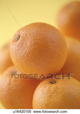 Stock Image - Pile of oranges, close up, orange background. Fotosearch