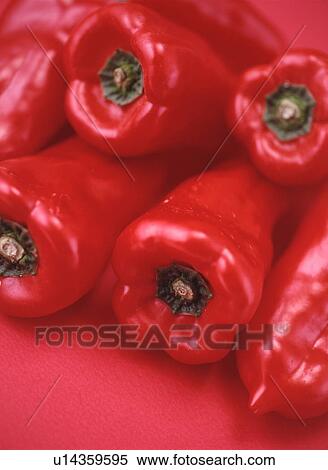 Stock Photography - Pile of red bell peppers, close up, red background. Fotosearch
