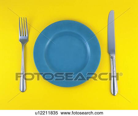 Stock Photography - Plate, fork and table knife on yellow background. Fotosearch