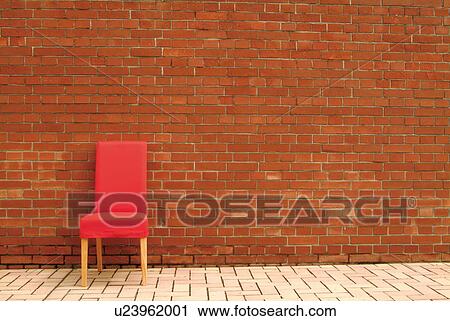 Stock Image - Red chair at brick wall, copy space. Fotosearch