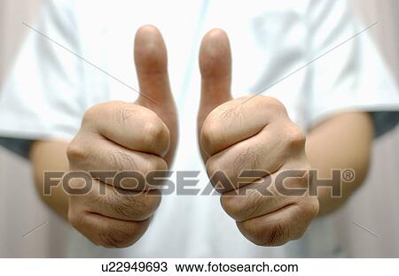 Stock Image - Shiatsu masseuse with his thumbs up. Fotosearch