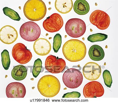 Stock Photograph - Sliced vegetables and fruits, white background, full frame. Fotosearch
