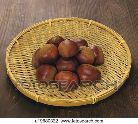 Stock Image - Stack of chestnuts on colander. Fotosearch