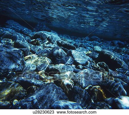Stock Image - Stones in clear river. Fotosearch