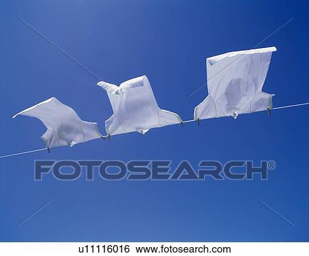 Three T-shirts being hanged out under blue sky, blue background View Large Photo Image Stock Photograph - Three T-shirts being hanged out under blue sky, blue background. Fotosearch
