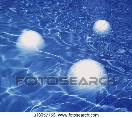 Stock Image - Three white balls floating on water, computer graphic. Fotosearch