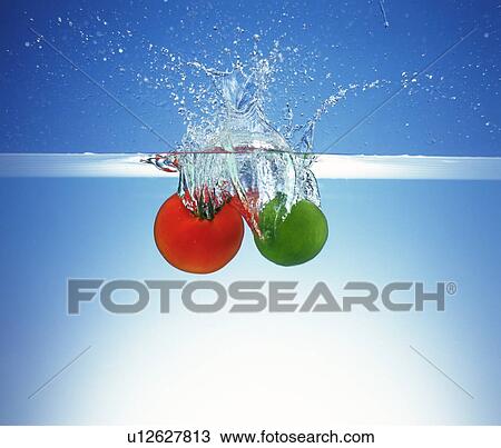 Tomato and lemon dropped in water, white background View Large Photo Image Stock Image - Tomato and lemon dropped in water, white background. Fotosearch