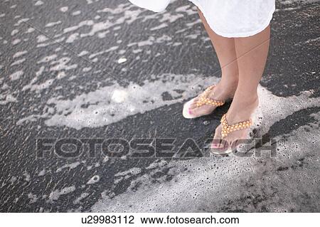 Stock Image - Woman standing on surf. Fotosearch