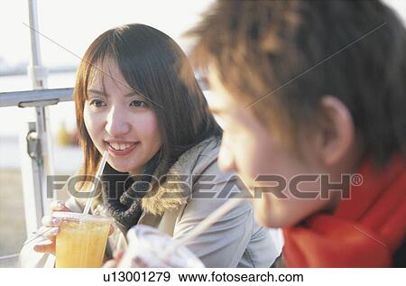Young couple drinking juice beside the beach, smiling View Large Photo Image Stock Photo - Young couple drinking juice beside the beach, smiling. Fotosearch