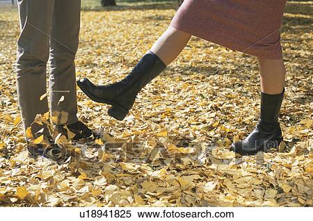 Young couple standing on autumn fallen leaves View Large Photo Image Stock Photography - Young couple standing on autumn fallen leaves. Fotosearch