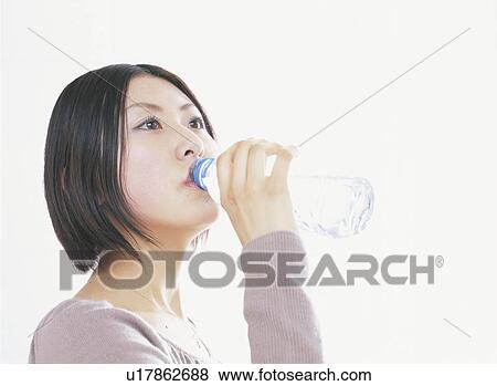 Young woman drinking bottle of water, white background View Large Photo Image Stock Photo - Young woman drinking bottle of water, white background. Fotosearch
