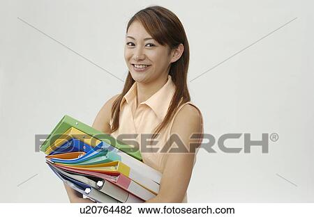 Stock Image - Young Woman Holding Piled Files. Fotosearch