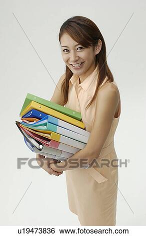 Stock Photograph - Young Woman Holding Piled Files. Fotosearch