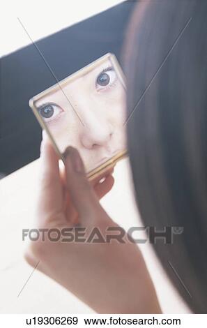 Young woman looking at mirror View Large Photo Image Stock Photo - Young woman looking at mirror. Fotosearch