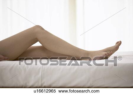 Young woman lying on bed View Large Photo Image Stock Photography - Young woman lying on bed. Fotosearch