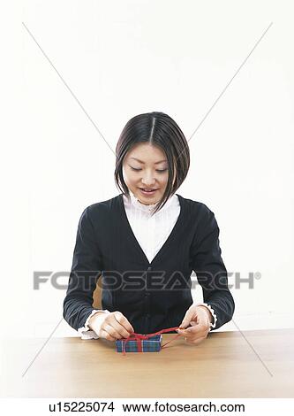 Young woman opening a gift box, smiling, white background View Large Photo Image Picture - Young woman opening a gift box, smiling, white background. Fotosearch