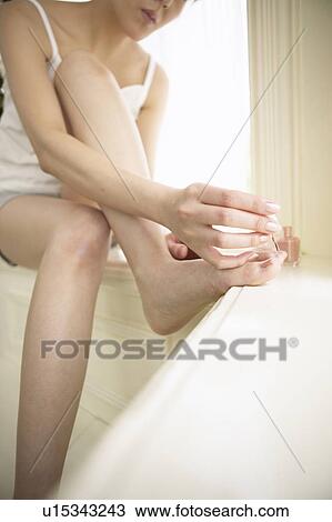 Young woman polishing toenails View Large Photo Image Stock Image - Young woman polishing toenails. Fotosearch