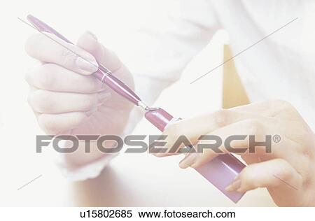 Young woman putting brush on lipstick, close up View Large Photo Image Stock Photography - Young woman putting brush on lipstick, close up. Fotosearch