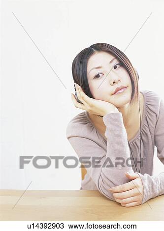 Young woman wearing headphones, looking away, white background View Large Photo Image Stock Image - Young woman wearing headphones, looking away, white background. Fotosearch