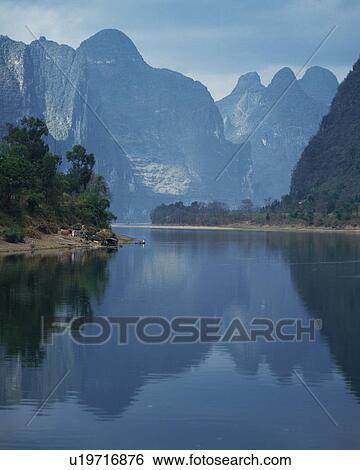 Mountain range reflected in still lake, Guilin, China View Large Photo Image Stock Photograph - Mountain range reflected in still lake, Guilin, China. Fotosearch