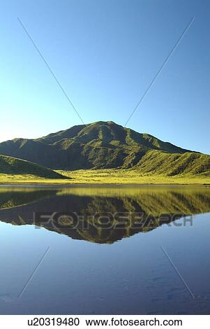Stock Image - Mt. Aso reflected in a calm lake, Kumamoto Prefecture, Japan. Fotosearch