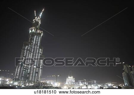 Stock Image - Construction Of Buildings In Dubai At Night. Fotosearch
