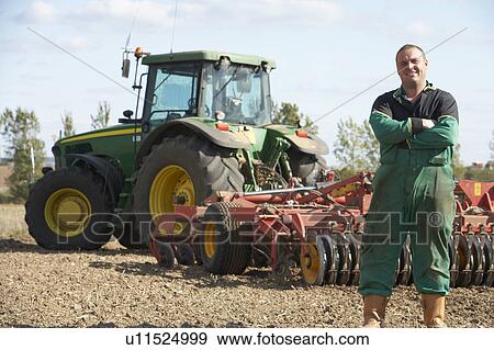 Stock Photo - Driver Standing In Front Of Tractor. Fotosearch