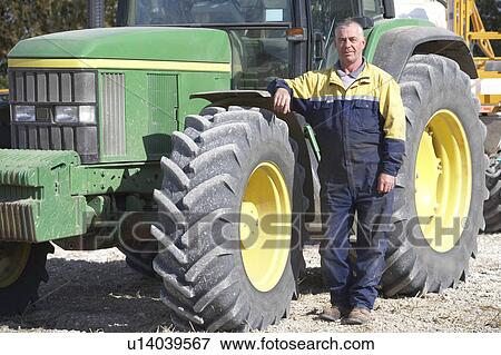 Stock Photo - Driver Standing In Front Of Tractor. Fotosearch