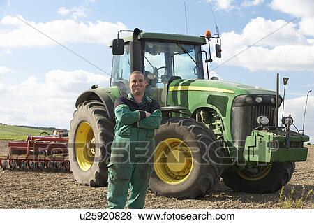 Stock Photo - Driver Standing In Front Of Tractor. Fotosearch