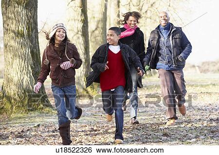 Stock Photograph - Family Running Through Autumn Countryside. Fotosearch