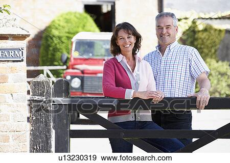 Farmer And Wife Looking Over Farm Gate View Large Photo Image Stock Photo - Farmer And Wife Looking Over Farm Gate. Fotosearch