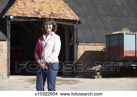 Farmer's Wife Standing In Front Of Farm Buildings View Large Photo Image Picture - Farmer's Wife Standing In Front Of Farm Buildings. Fotosearch