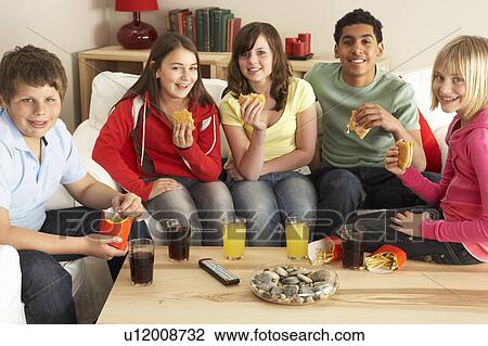 Stock Image - Group Of Children Eating Burgers At Home. Fotosearch