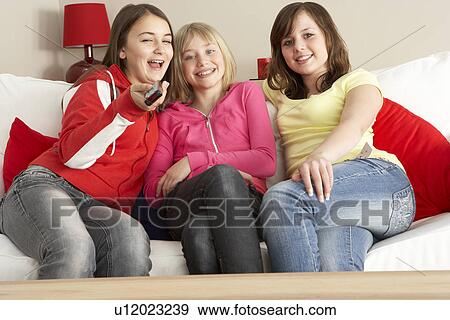 Stock Photo - Group Of Three Girls Watching TV. Fotosearch