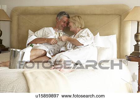 Middle Aged Couple Enjoying Champagne In Bedroom View Large Photo Image Stock Photo - Middle Aged Couple Enjoying Champagne In Bedroom. Fotosearch