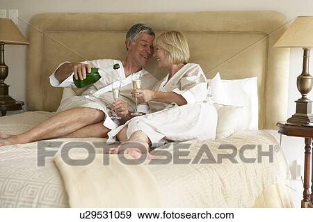 Middle Aged Couple Enjoying Champagne In Bedroom View Large Photo Image Stock Photo - Middle Aged Couple Enjoying Champagne In Bedroom. Fotosearch
