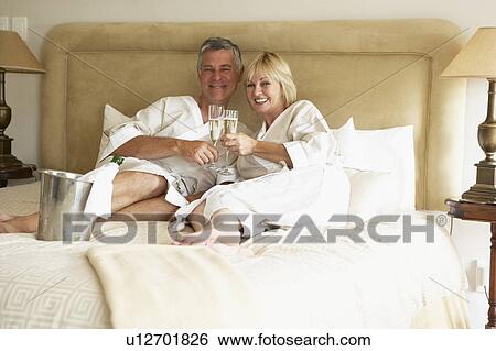 Middle Aged Couple Enjoying Champagne In Bedroom View Large Photo Image Stock Photograph - Middle Aged Couple Enjoying Champagne In Bedroom. Fotosearch