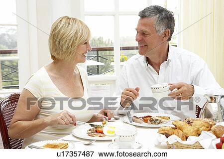 Stock Photo - Middle Aged Couple Enjoying Hotel Breakfast. Fotosearch